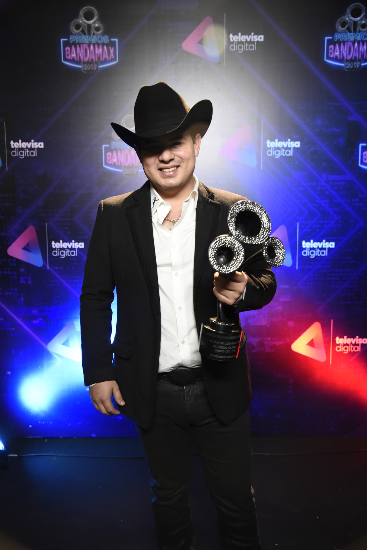 Alfredo Olivas posó muy orgulloso con su reconocimiento por Disco del Año. Su producción "El Día de los Muertos" fue lo que le consiguió este título.