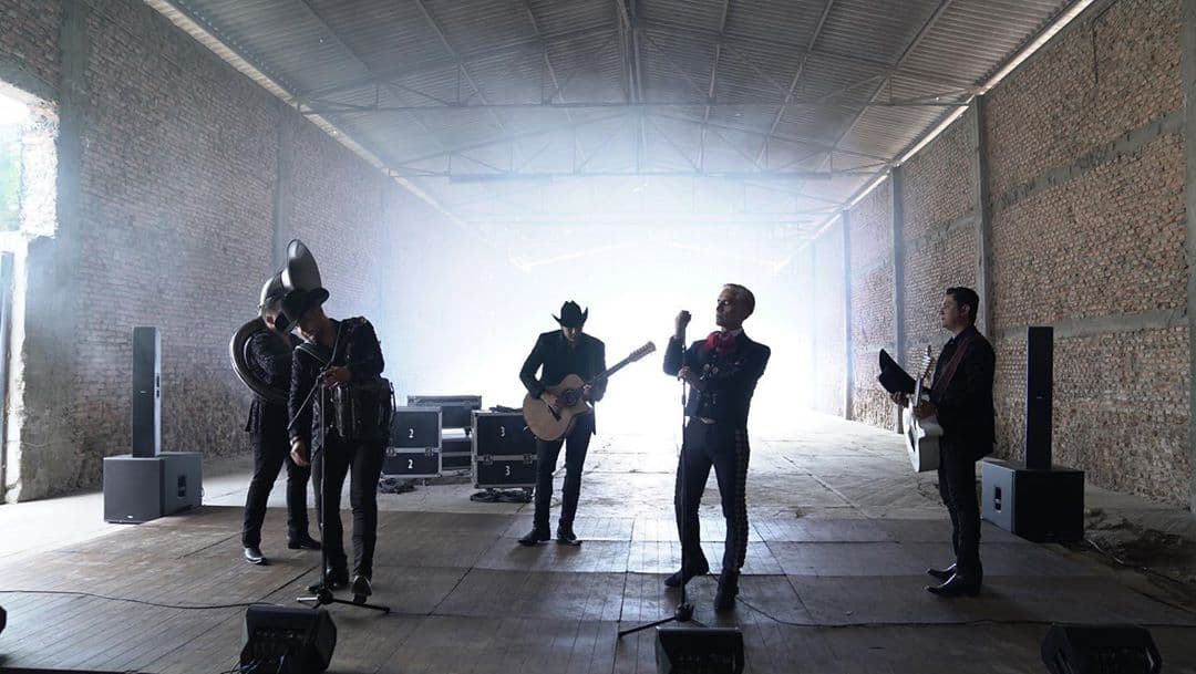 En el material se ve a Calibre 50 y Alejandro Fernández en una especie de bodegón compartiendo micrófonos.